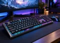 Tastatură mecanică de gaming cu iluminare RGB pe birou modern, alături de mouse și monitor pentru jocuri