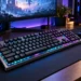 Tastatură mecanică de gaming cu iluminare RGB pe birou modern, alături de mouse și monitor pentru jocuri